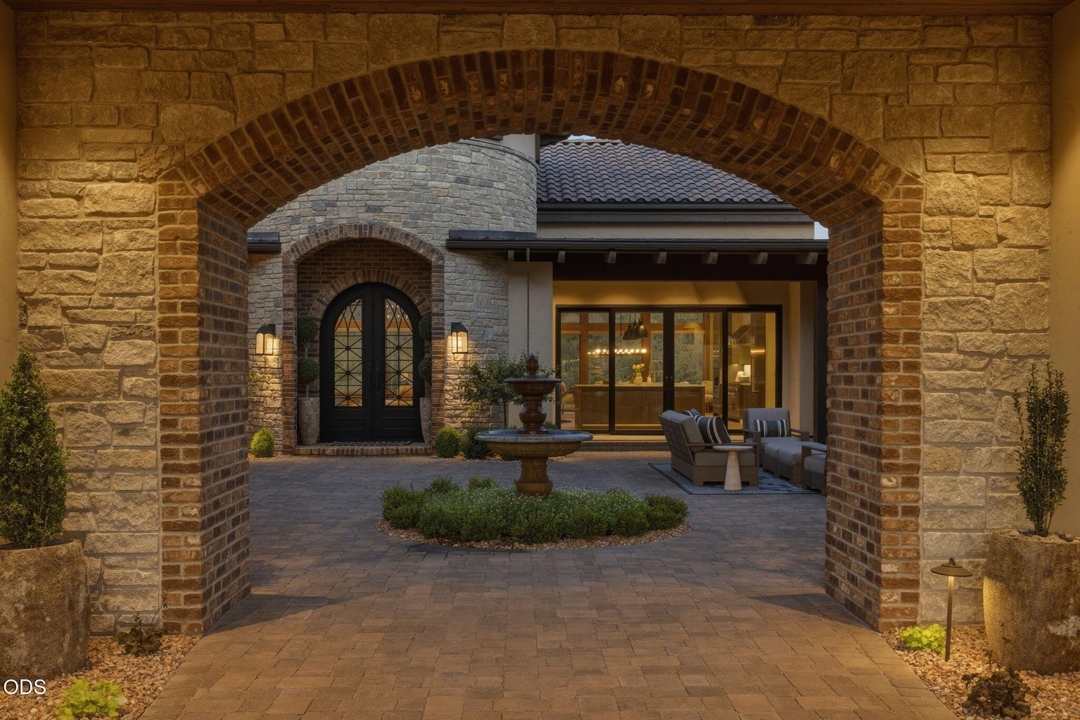 Entry courtyard, stone fountain, arched iron front door