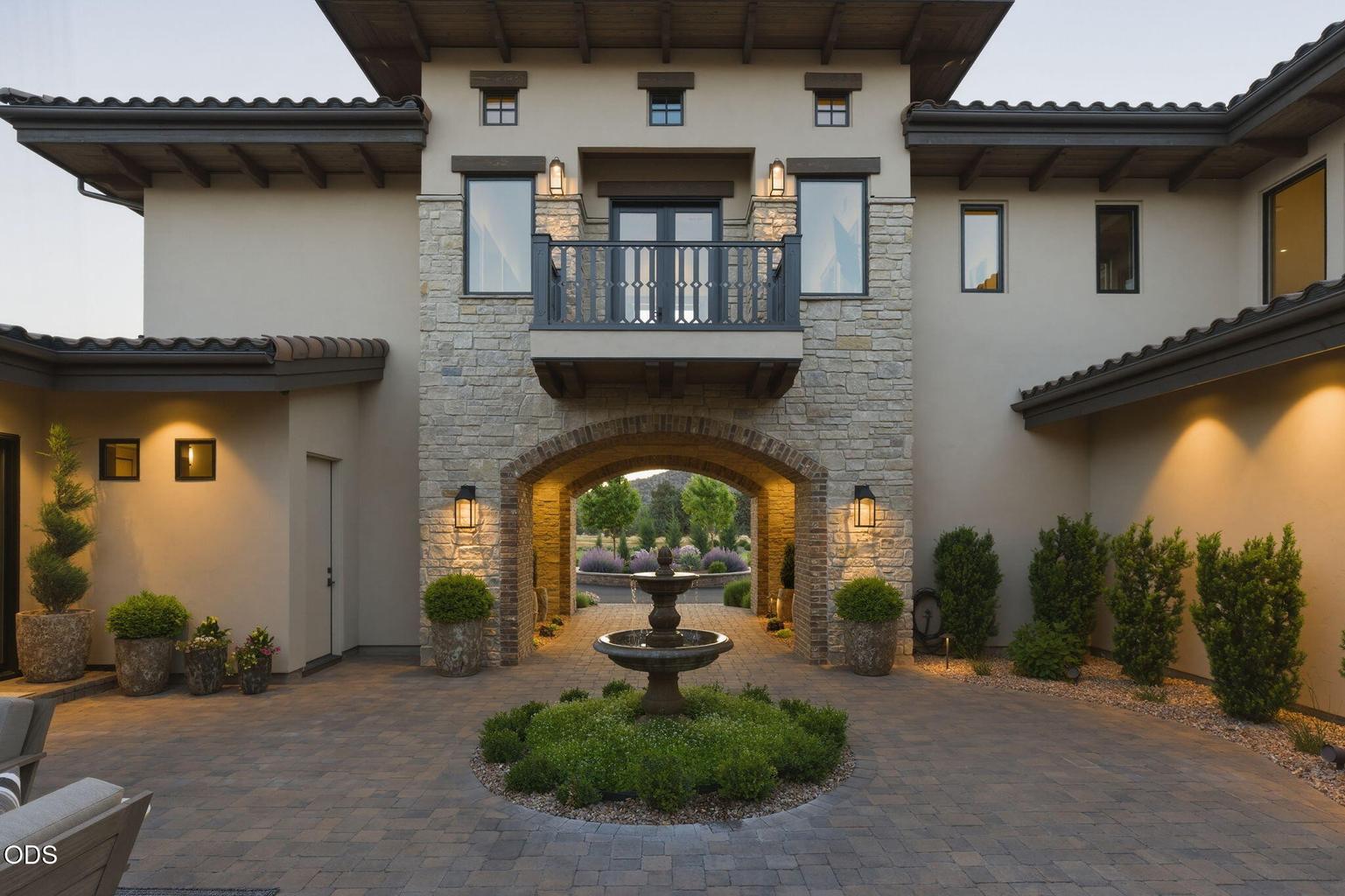 Courtyard looking out through arched passageway, upper balcony above