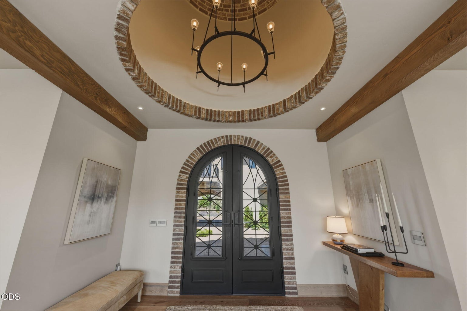 Entry foyer, arched iron double doors, brick rotunda ceiling, chandelier