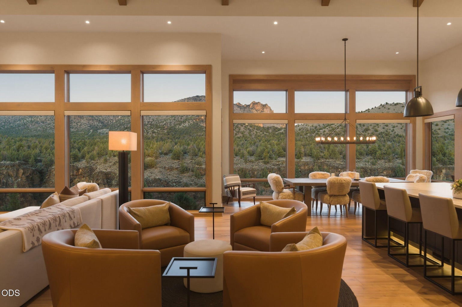 Open living and dining at dusk, canyon and rock views through full window wall