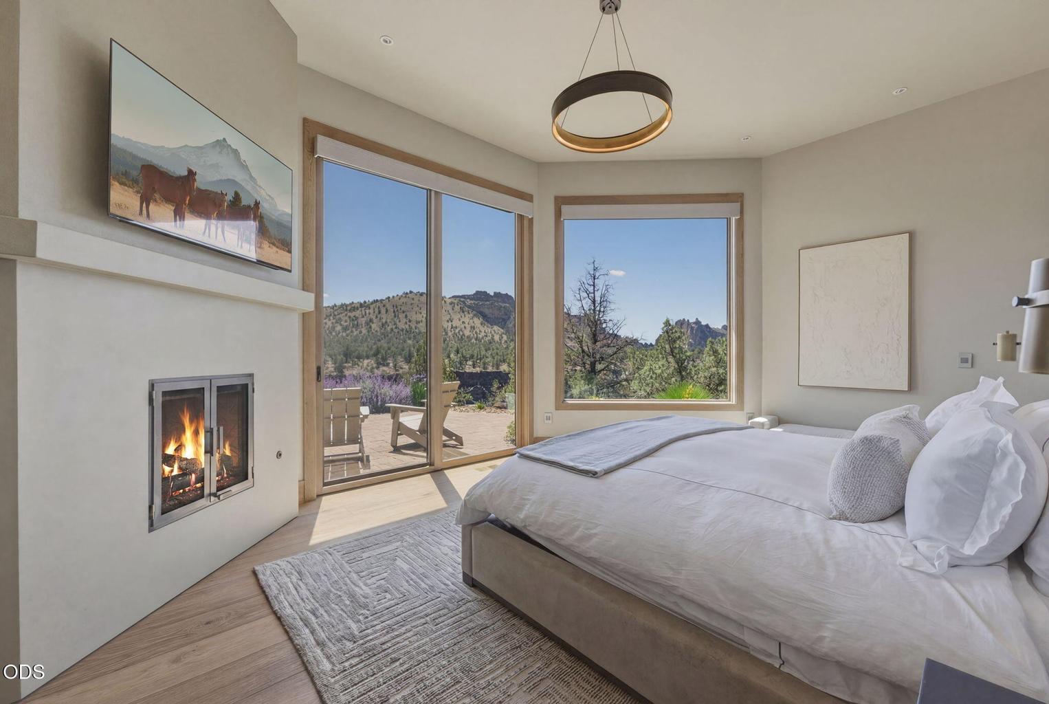 Primary suite, fireplace, dual windows with Smith Rock and canyon views