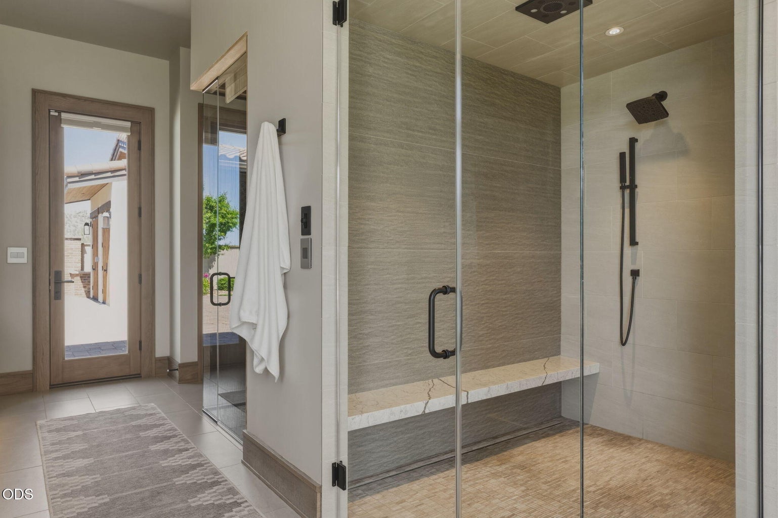 Primary bath steam shower, large format tile, marble bench, courtyard door