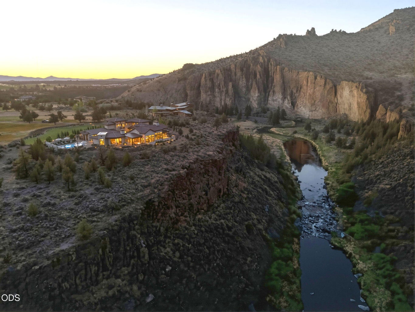 Estate lit at dusk from canyon floor, Crooked River and Smith Rock walls