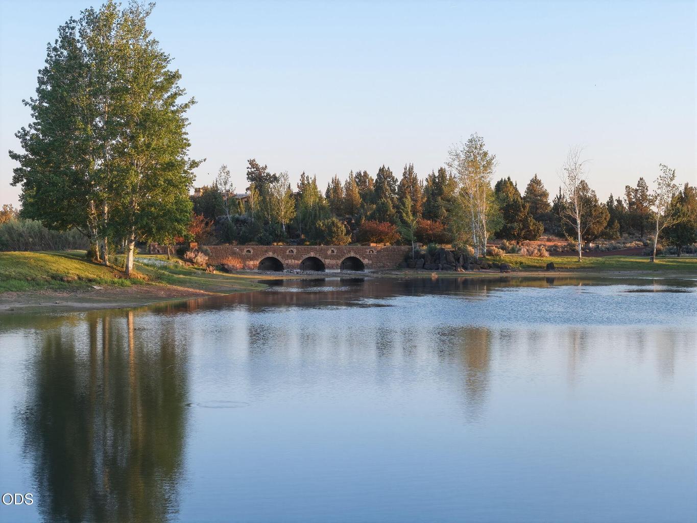 Ranch at the Canyons community pond and arched stone bridge at golden hour