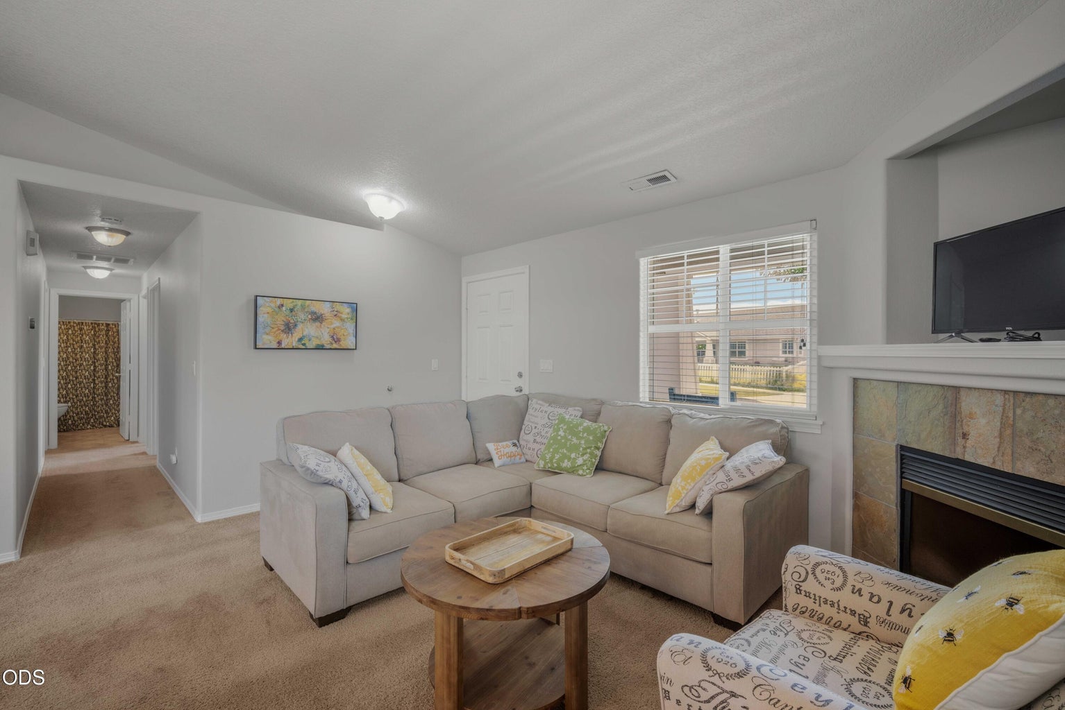 This living room view highlights the practical single-level layout, soft natural light, and easy access to the bedroom wing.