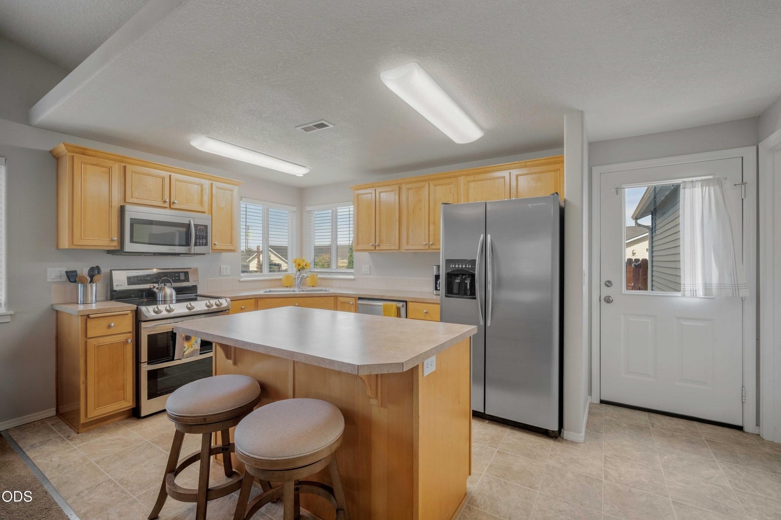 The kitchen offers abundant cabinetry, an island with seating, and a practical layout designed for everyday use.