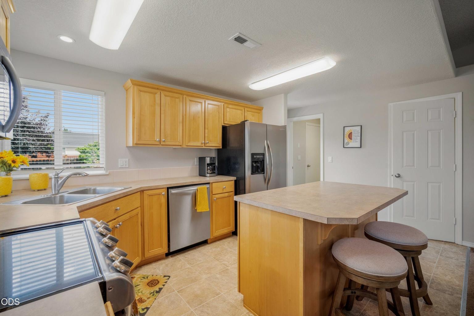 Generous cabinetry, island storage, and nearby pantry access add practical function to this comfortable kitchen.