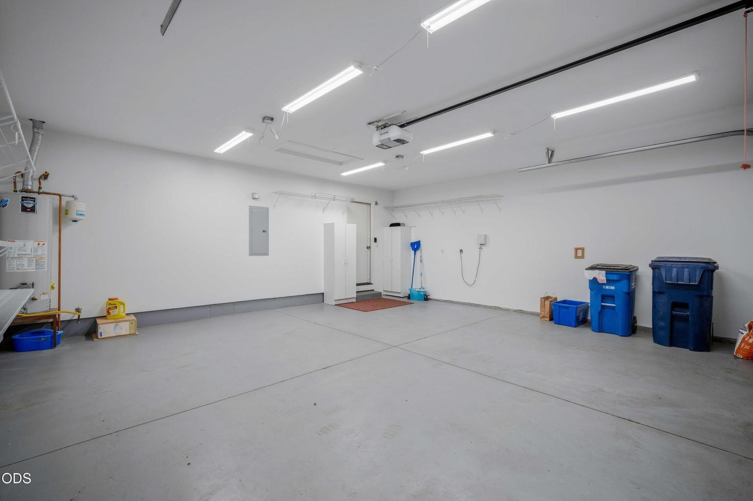 Bright lighting, wall shelving, and generous floor space make the garage especially functional for storage and hobbies.
