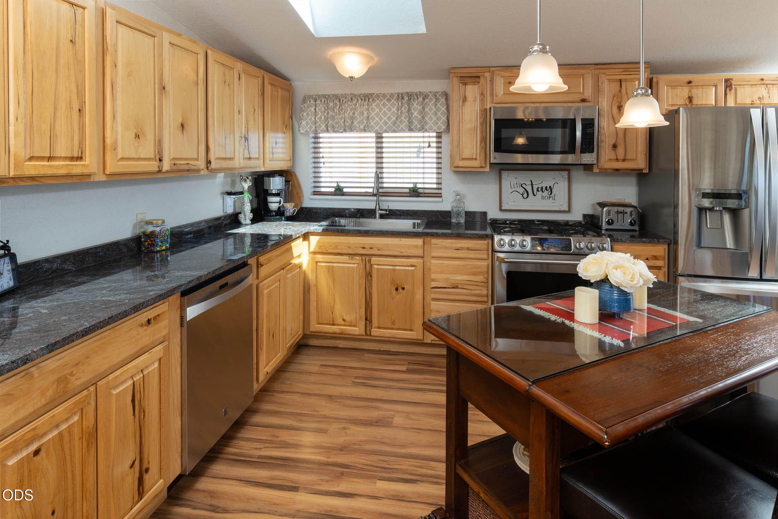 Hickory cabinets and granite countertops are the focal point of this total kitchen remodel, inclusive of stainless appliances and dual fuel range.