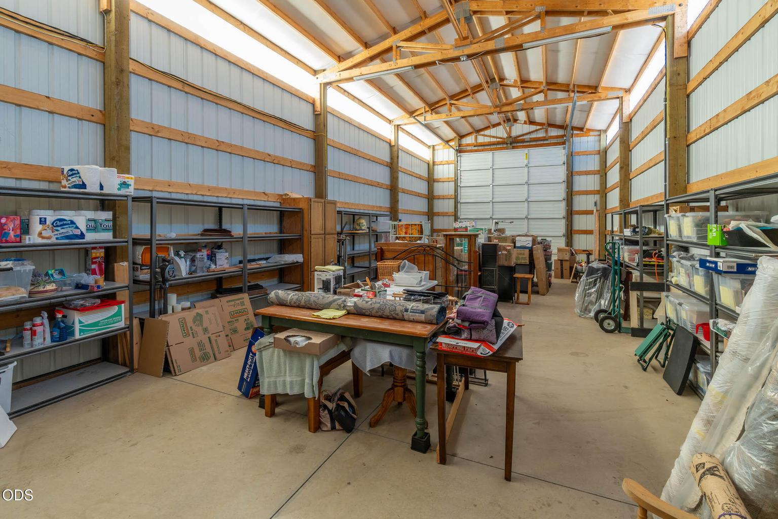 RV storage pole barn with 14' high door and concrete floors. Storage shelving is included.