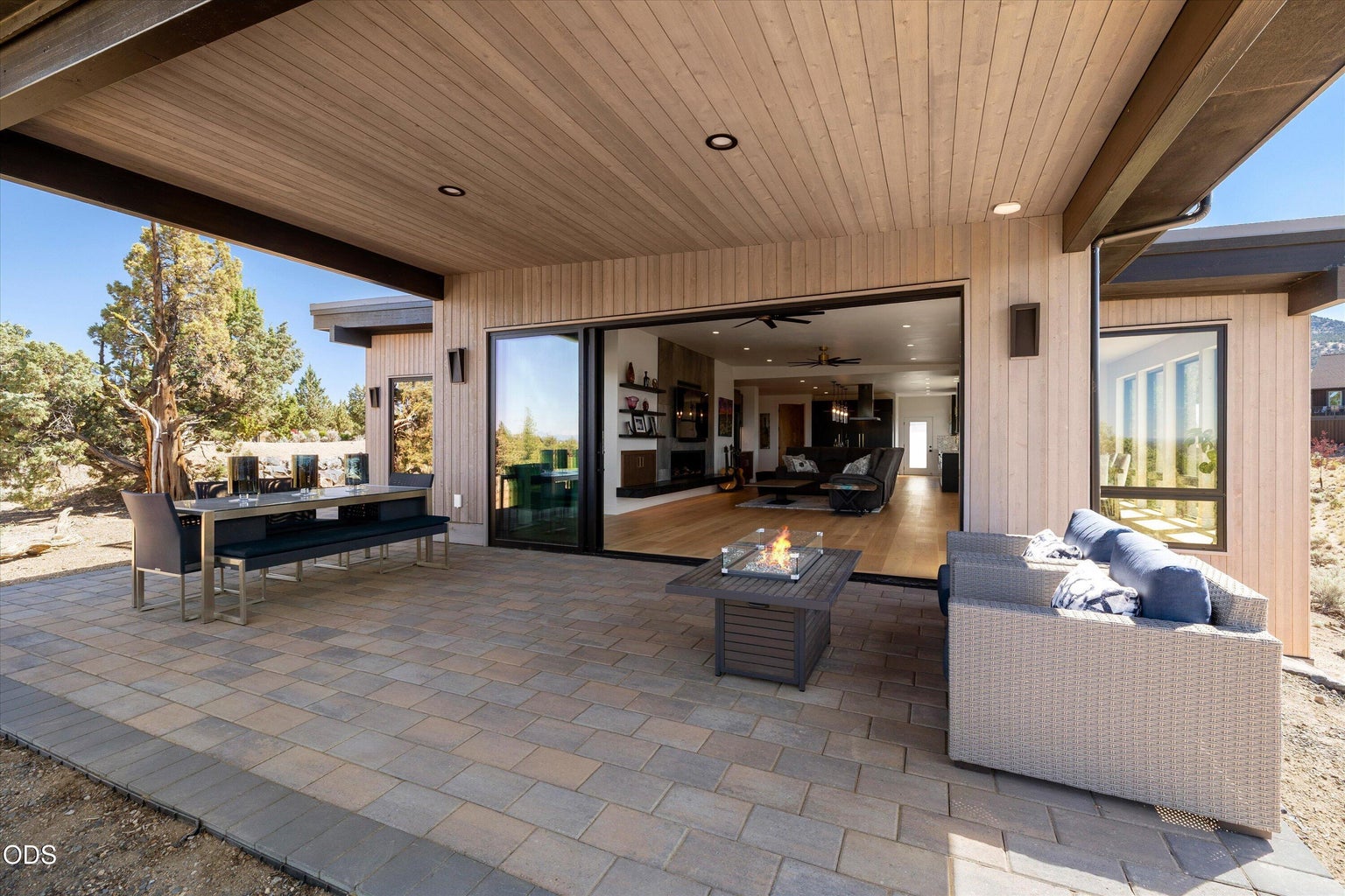 The glass wall opens to expand the living space onto a covered back patio