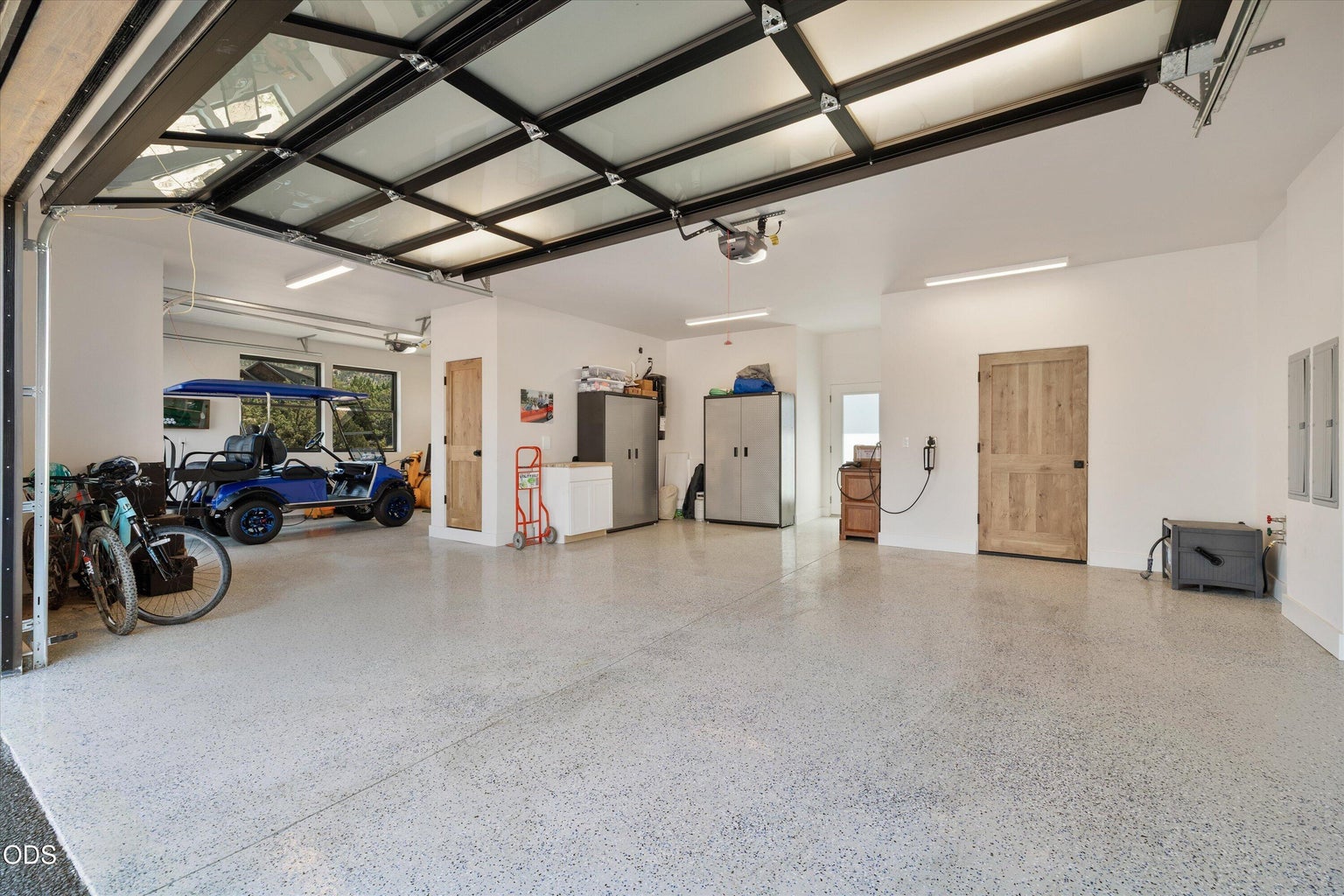 The garage offers an amazing workspace with epoxy floors, storage, and some separation for different vehicle types