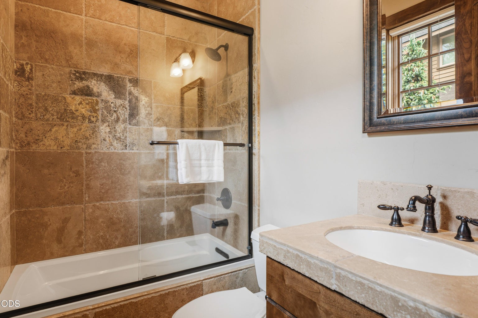 The adjoining guest bathroom features a tiled tub/shower surround.