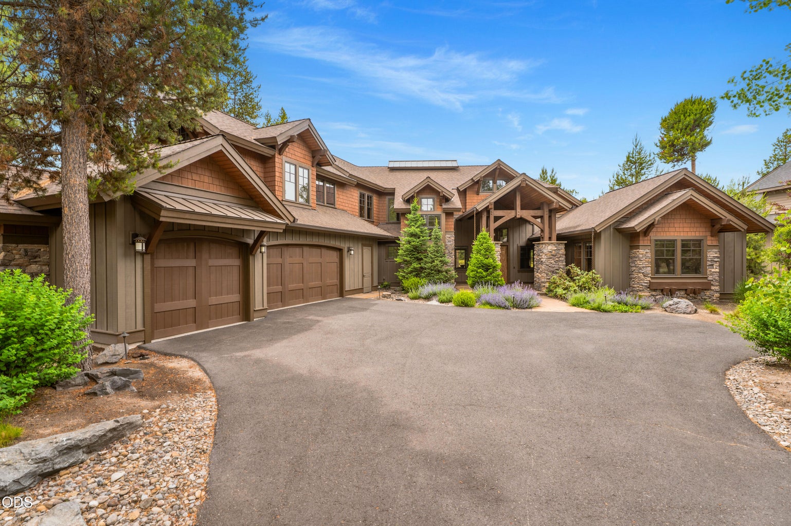 Stunning custom mountain retreat featuring timeless Northwest architecture, a welcoming covered entry, and an oversized three-car garage.
