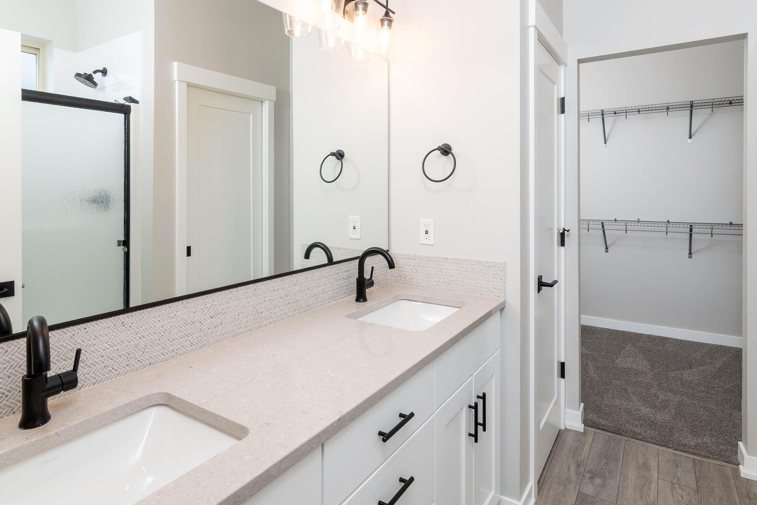 Primary en suite with dual under-mount sinks, linen closet and walk-in closet