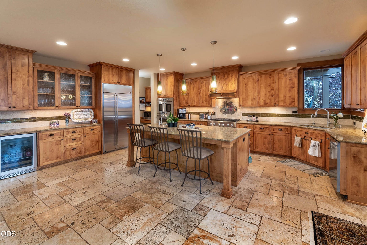 Travertine Floors; Huge Island with Bar Stools & the beverage fridge.