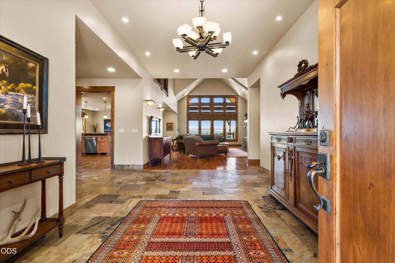 Tiled grand foyer leads to office, great room, primary bedroom, and hallway to stairs