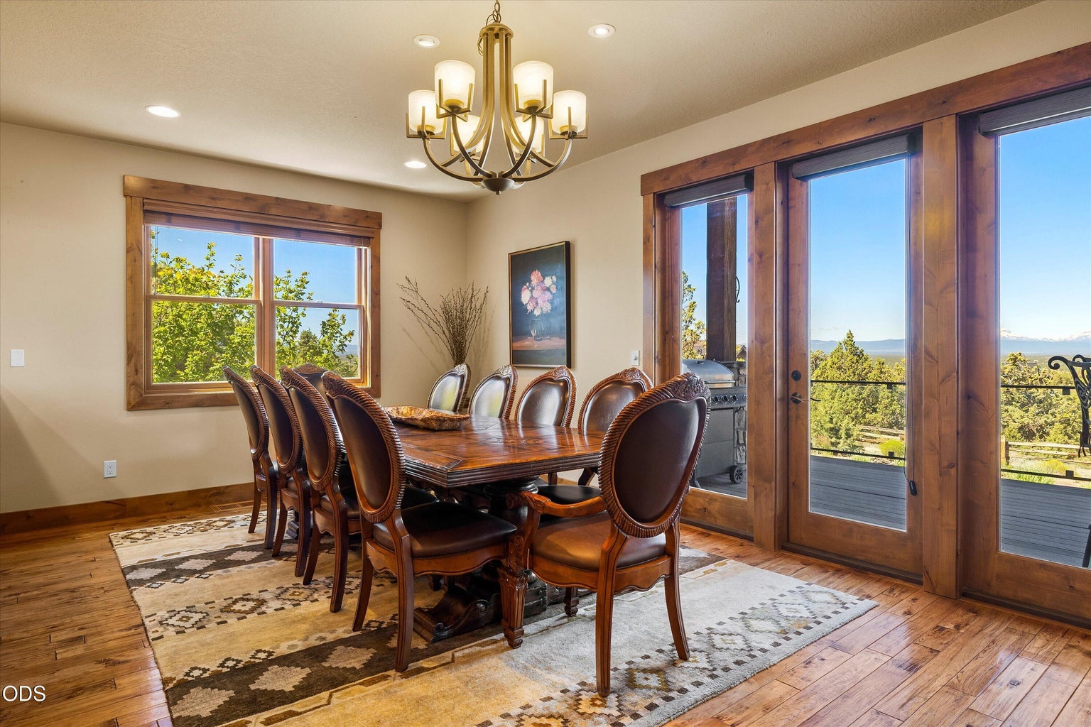 The dining room connects the great room and kitchen, with beautiful custom wood and glass doors leading to the covered, raised deck