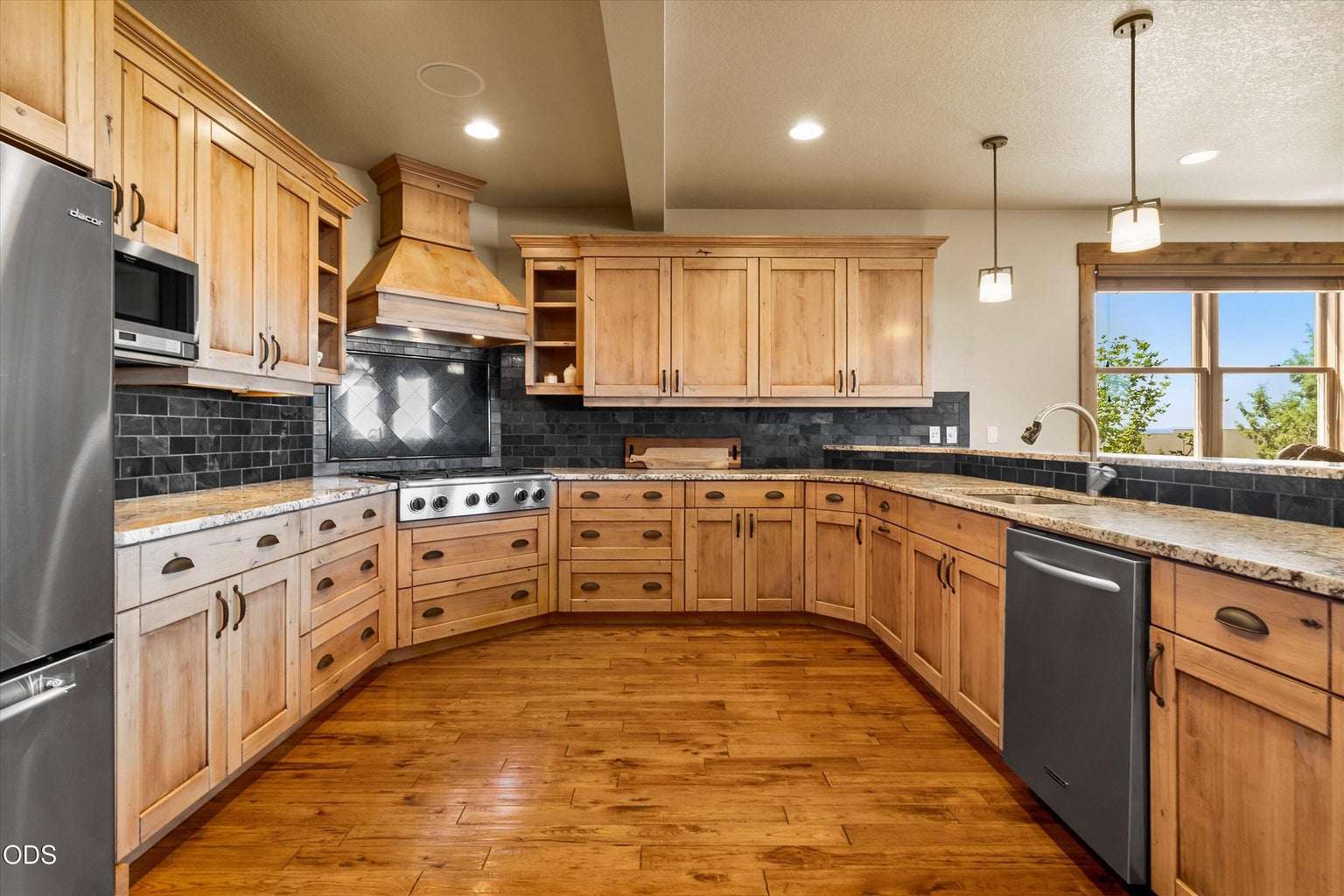 Kitchen with elongated breakfast bar, corner range and range hood