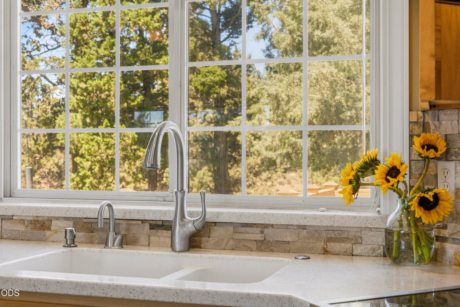 Kitchen window looks out on deck and backyard