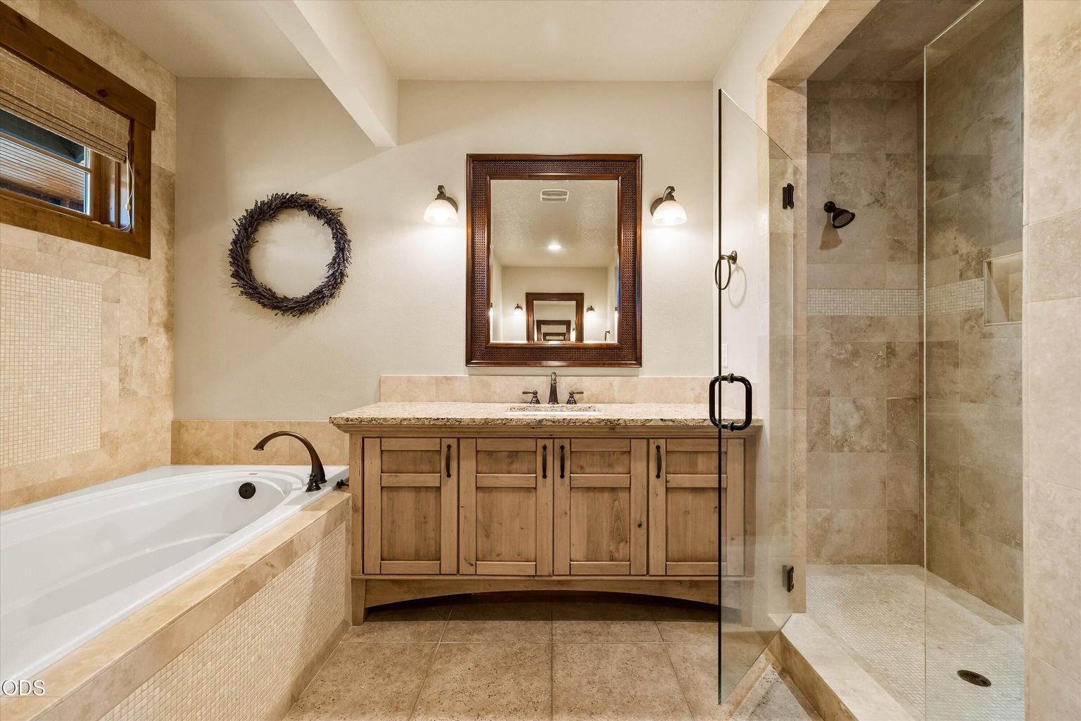 Oversized soaking tub with high windows for privacy and natural light. Walk-in shower