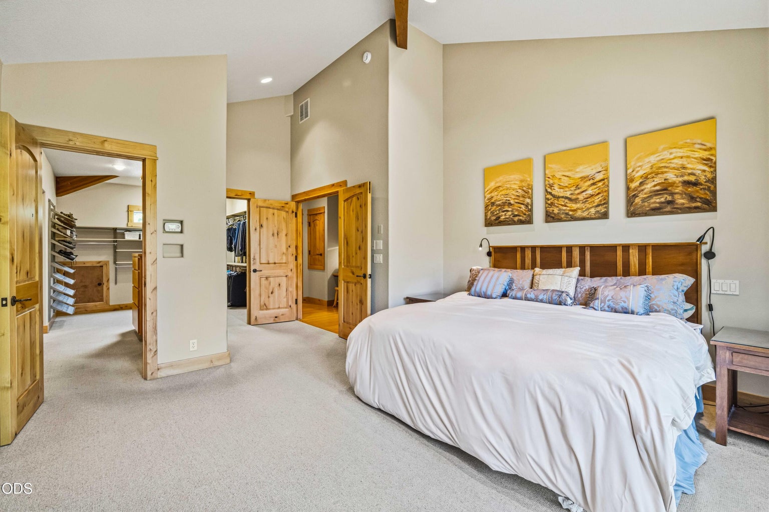 Generous proportions distinguish the primary bedroom, with high ceilings, warm wood doors and direct connections to extensive dressing, closet and bath areas.