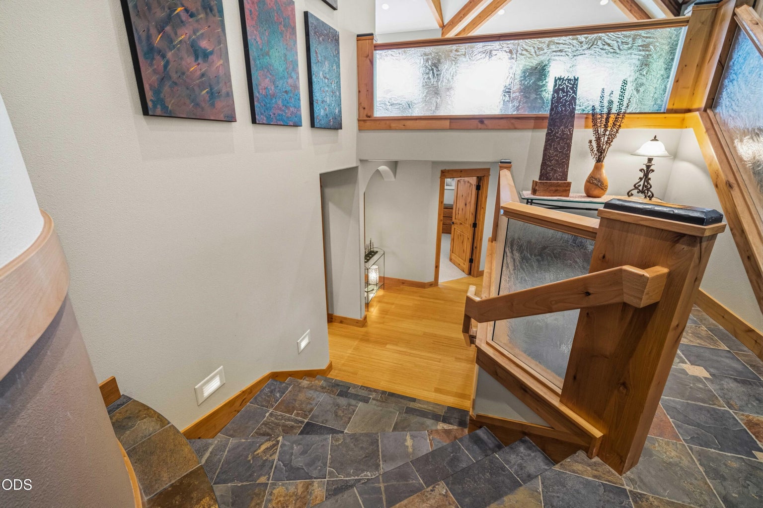 Short slate-covered stairs lead from the central entry landing to the lower living level, demonstrating the home’s easy split-level arrangement rather than a full flight of exterior entry stairs.