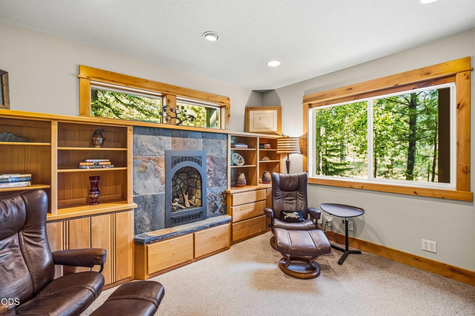 The dedicated library offers a quiet retreat with a second fireplace, extensive built-in cabinetry, forest views and room for reading, conversation or focused work.