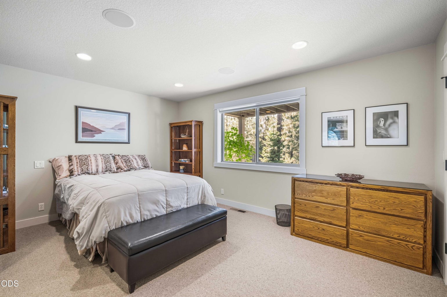 One of two lower-level guest suites, this spacious bedroom offers generous proportions, a broad forest-facing window and room for substantial furnishings. Its private bath access creates the comfort and independence of a secondary primary suite, ideal for extended family or overnight guests.