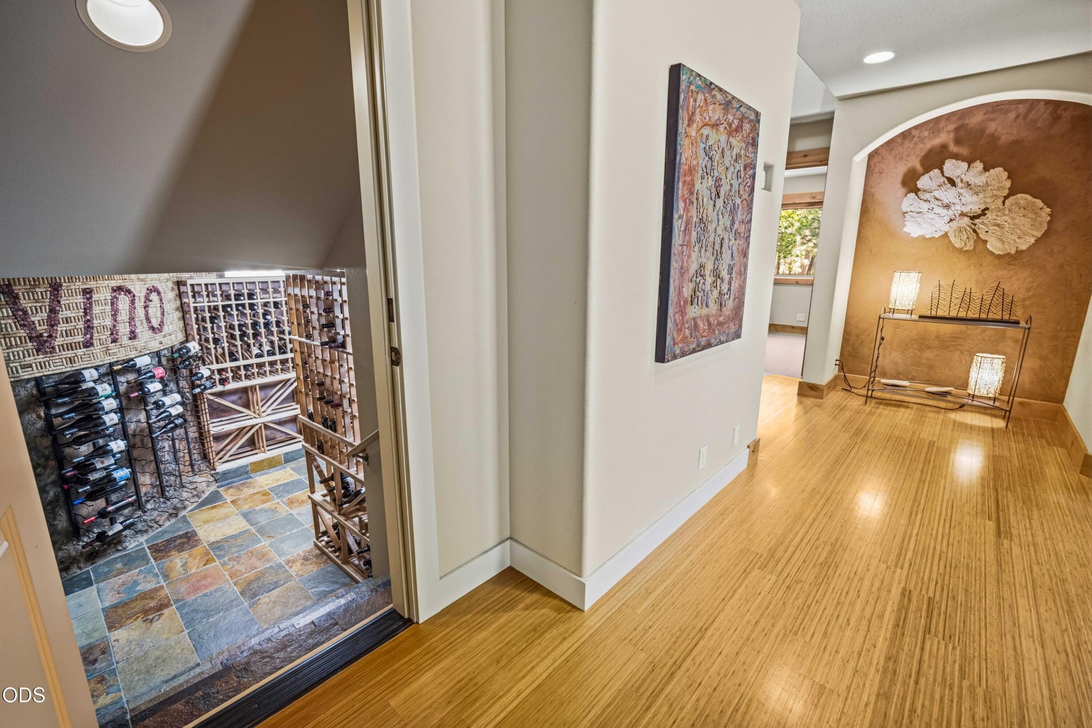 A discreet doorway off the lower hall reveals one of the home’s most memorable amenities, a dedicated wine cellar tucked beneath the stair structure.