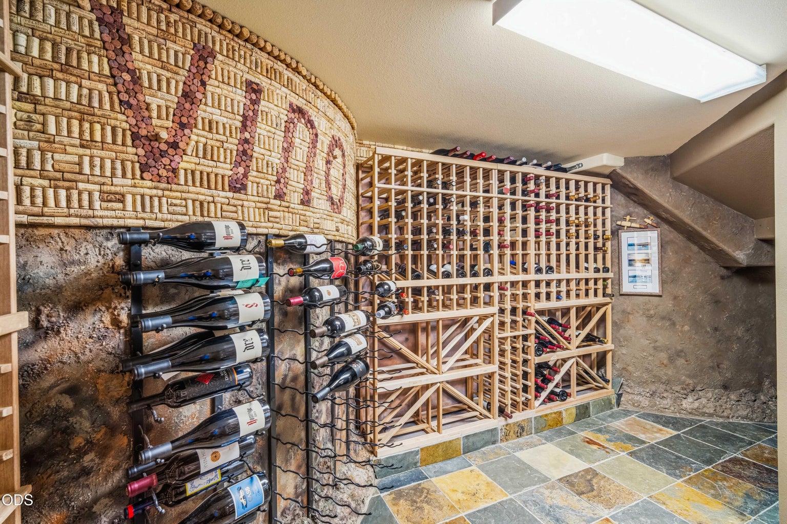The custom wine cellar features extensive bottle storage, slate flooring, sculptural cork artwork and atmospheric finishes, creating a distinctive destination for collectors and entertaining.