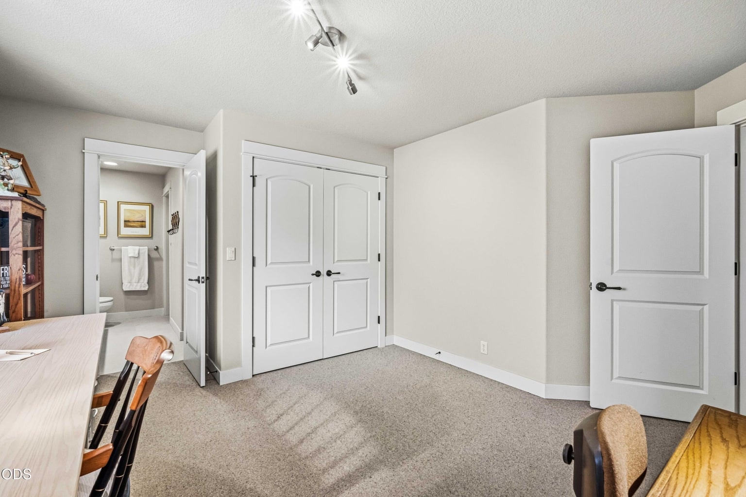 A second view confirms the room’s full bedroom proportions, broad closet storage and direct connection to its private sink and toilet area. The adjoining shared shower links this suite to a separate hall-side vanity and toilet area, creating a highly functional arrangement for guests.