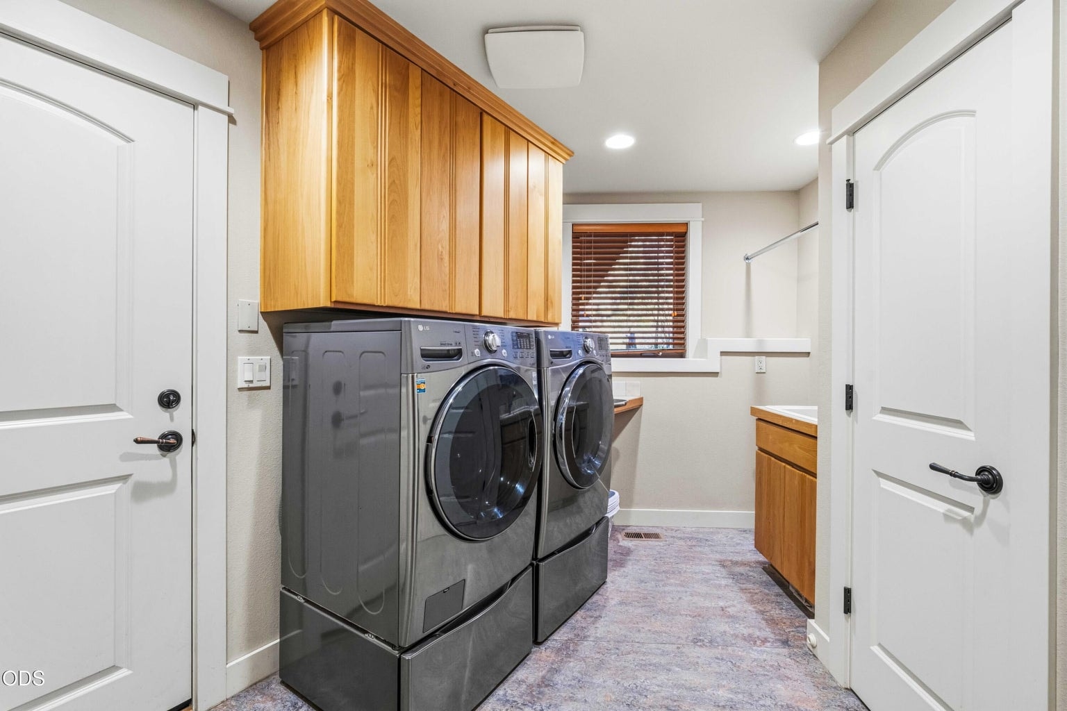 The dedicated laundry room provides full-size appliances, extensive overhead cabinetry, a utility sink, hanging space and room for folding and household organization.