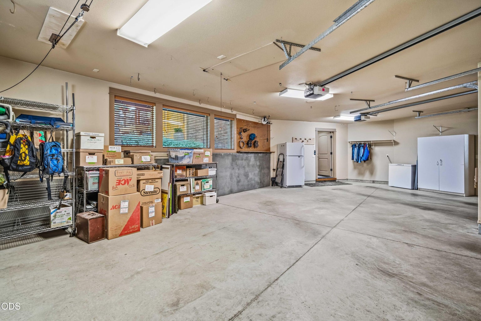 A second garage view demonstrates the depth and flexibility of the space, with room for vehicles, bicycles, seasonal equipment, freezers and extensive organized storage.