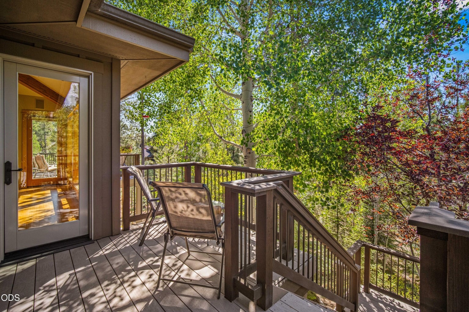The private deck adjoining the primary suite provides a quiet elevated retreat among aspens and pines, oriented toward Mount Bachelor and separate from the main entertaining deck.