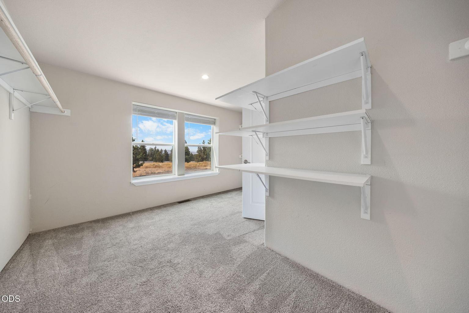 Primary closet has nice natural light and lots of shelving options
