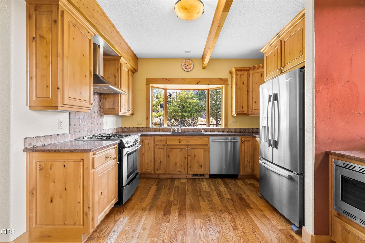 The kitchen bay window frames a beautifully landscaped backyard that mixes natural high desert surroundings with thoughtful living areas