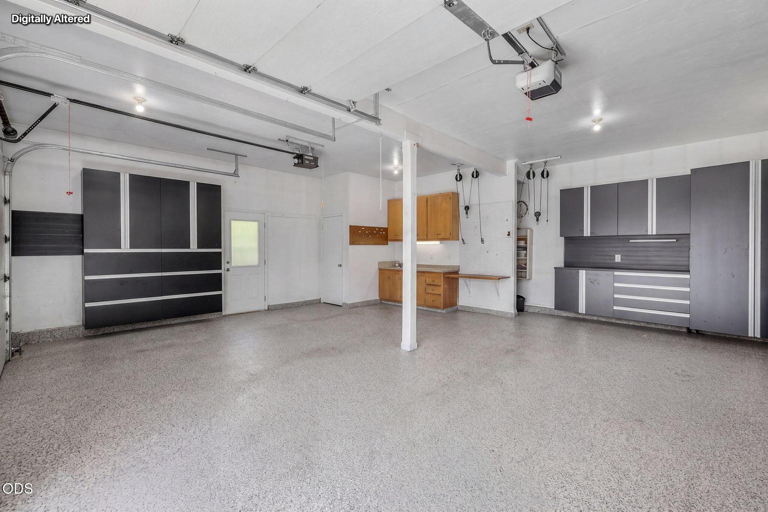 Oversized 2-car garage with metal storage units and epoxy floor.