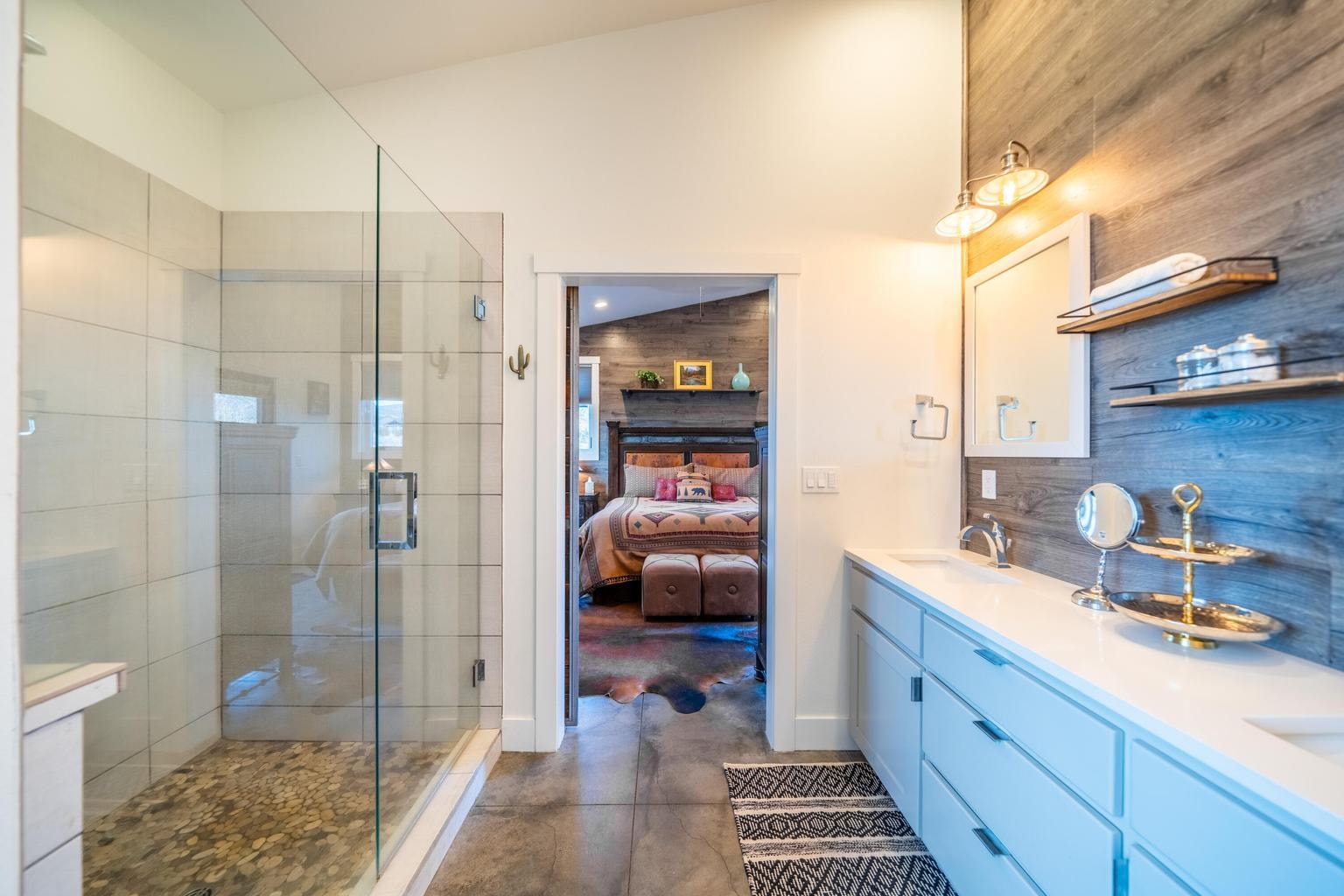 Double vanity and oversized tiled shower off primary bedroom