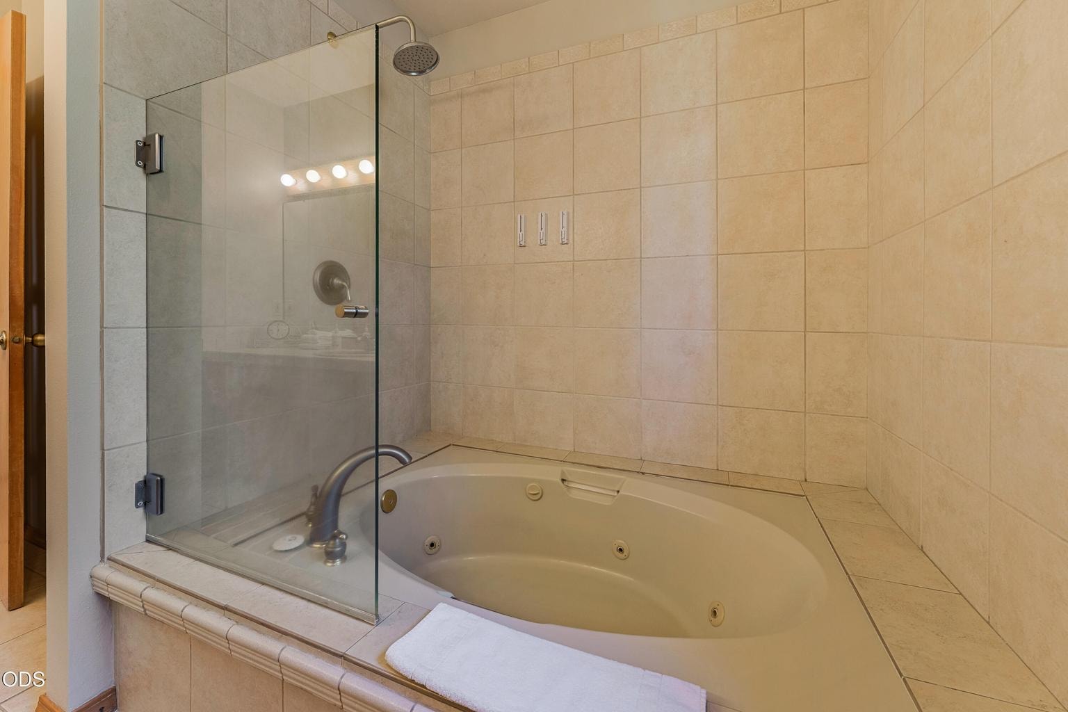 Primary bathroom with whirlpool tub and rain shower
