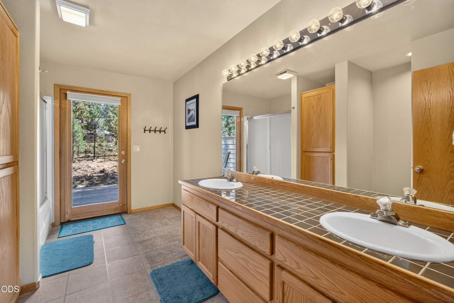A full guest bath serves the two additional downstairs bedrooms and includes direct access to the back of the home, adding extra convenience for family, guests and outdoor living.