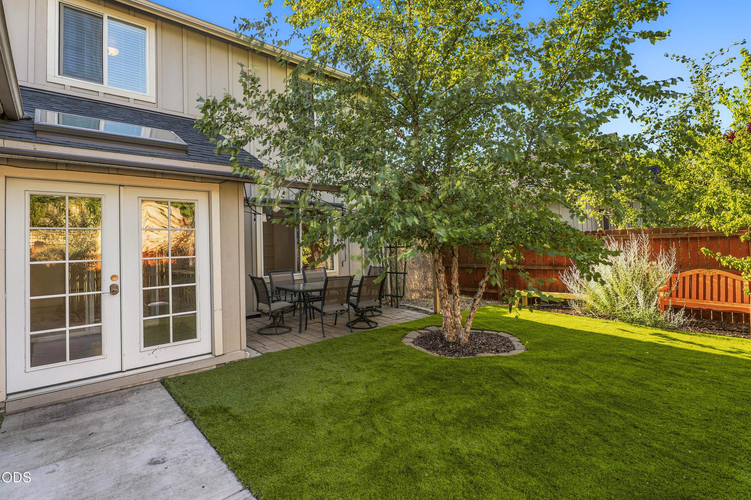 Sunroom opens to a private backyard with easy maintenance turf- and saves on water usage