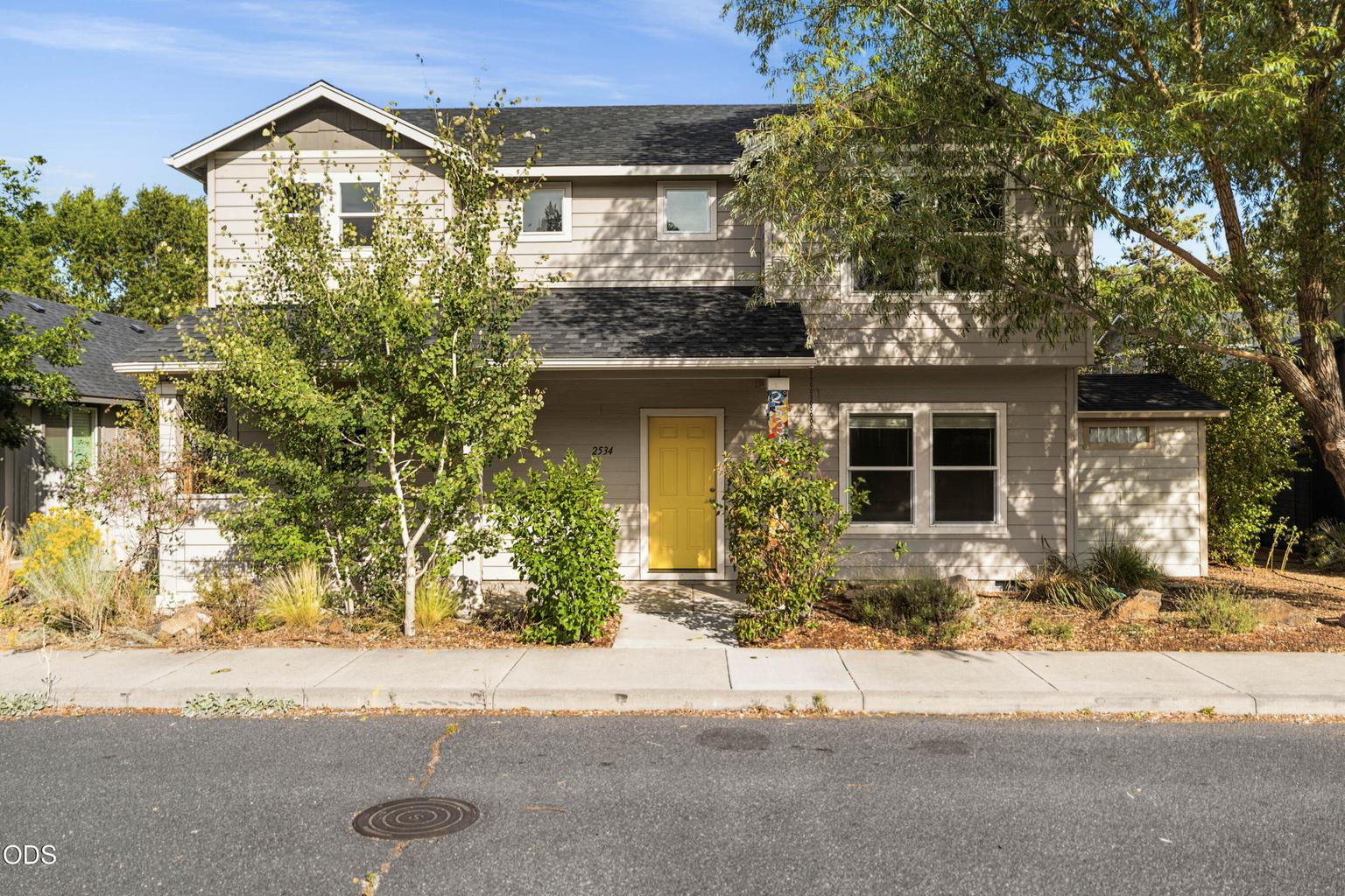 Welcoming front yard with mature trees. Solar on roof is paid in full. Low utility bills