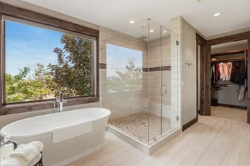 Soak in the deep, free-standing tub and feel at one with the natural landscape out the window, or enjoy the separate glass-enclosed walk-in shower. Convenient walk-in closet accessed through bathroom