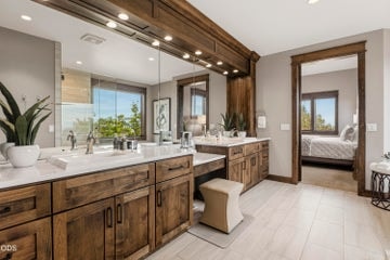 Double vanities plus third seated make-up station, ample storage, custom wood framing with special lighting