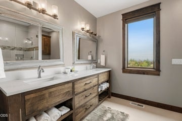 An oversized bathroom with double vanity is connected to the bonus room